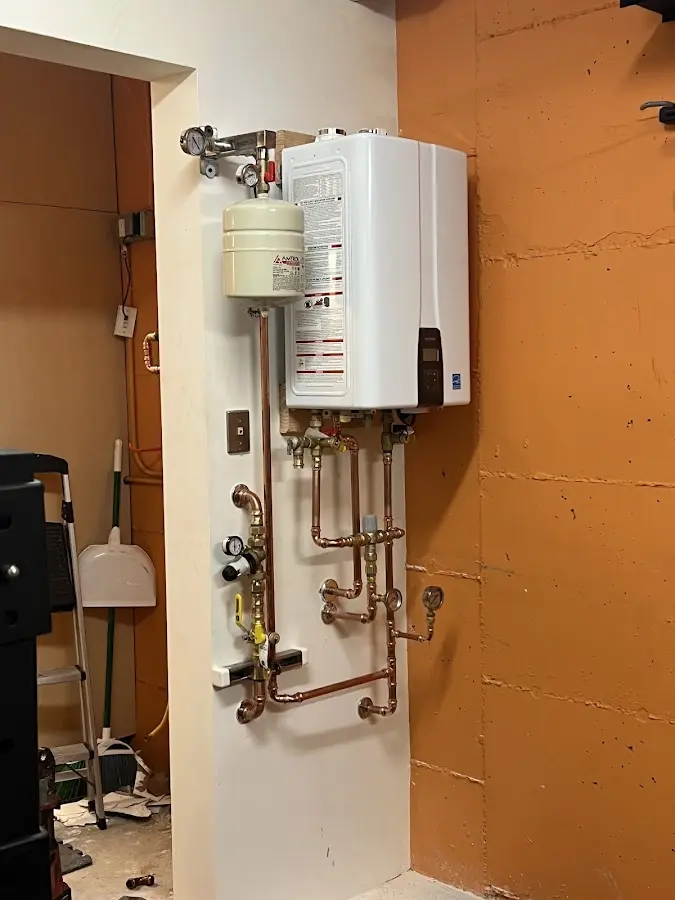 Plumbing technician inspecting water heater connections in Richmond